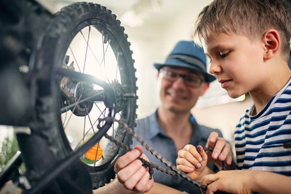 Helping a kid repair his bike chain