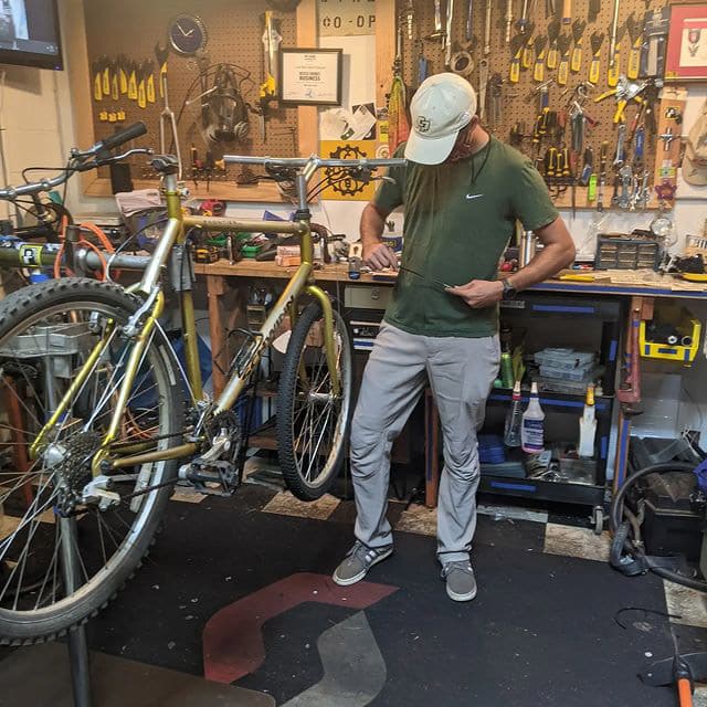 A volunteer working on a bike inside the shop
